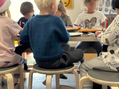 Børn sidder ved bord